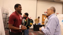 A Student is conversing with a faculty member at the Dream Makers Summit
